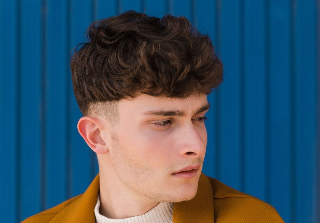Man with a textured French crop, short choppy fringe and faded sides